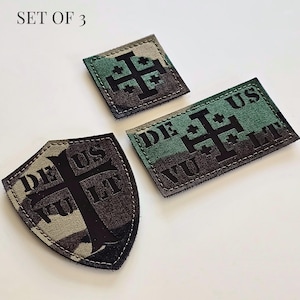 Può includere: Set di 3 toppe mimetiche con un disegno a croce di Gerusalemme nera. Una toppa è quadrata, una rettangolare e una a forma di scudo. Il testo "DEUS VULT" è stampato su due delle toppe. Le toppe sono bordate con cuciture bianche.