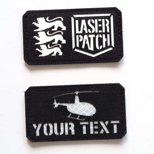May include: Two black rectangular patches with white laser cut designs. The top patch has three white lions and the text "LASER PATCH". The bottom patch has a white helicopter and the text "YOUR TEXT".