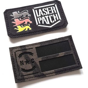 Pode incluir: Duas etiquetas retangulares. A etiqueta superior é preta com o texto "LASER PATCH" em branco e três silhuetas de leões em cinza, vermelho e amarelo. A etiqueta inferior é camuflada com as letras "N*C" e uma estrela.