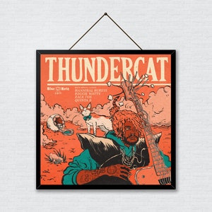 Puede incluir: Un póster enmarcado en negro con una ilustración roja, naranja y amarilla de un músico tocando un bajo. El póster tiene el texto "THUNDERCAT" en letras blancas grandes en la parte superior y "Blue Note" en letras azules en la esquina inferior izquierda. El póster también incluye el texto "with special guests:  HANNNIBAL BURESS, REGGIE WATTS, ZACH FOX, QUINTON "Q"  DORSEY" en letras blancas más pequeñas.