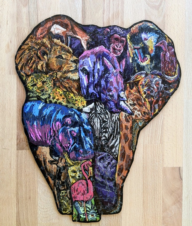 Puede incluir: Un rompecabezas colorido que representa una variedad de animales, incluyendo un le&oacute;n, una cebra, un rinoceronte, un hipop&oacute;tamo, un mono y un flamenco. Los animales est&aacute;n dispuestos en un patr&oacute;n circular, creando un dise&ntilde;o visualmente atractivo.