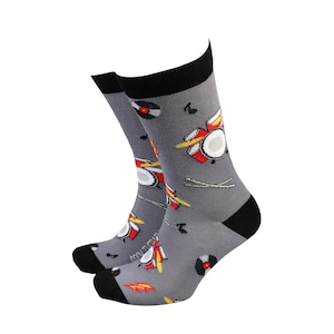 May include: A pair of grey socks with a black cuff. The socks feature a colourful drum set, musical notes, and vinyl records.