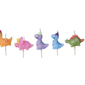 Op de afbeelding: Een set van vijf dinosaurusvormige verjaardagskaarsen. Elke kaars heeft een andere kleur, waaronder oranje, roze, paars, blauw en groen. Elke dinosaurus draagt een feesthoed en is op een houten stok gemonteerd.