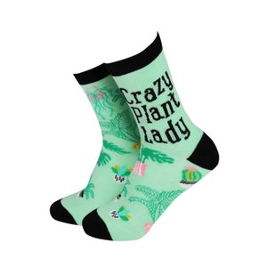 May include: A pair of green socks with a black and white print of plants and the text "Crazy Plant Lady".