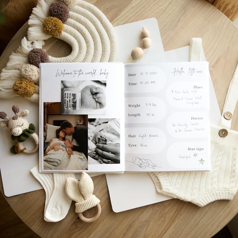 An open pregnancy journal with photos and handwritten details. The book includes a photo of a baby's hand, a couple, and a baby's foot. A crocheted giraffe rattle, bunny ear rattle, and a pair of socks are also visible.