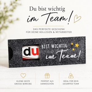 May include: A dark gray felt sleeve with a rectangular cutout revealing a white tube with the text 'du' in black and red. The sleeve features the white text 'BIST WICHTIG im Team!' and three yellow stars. The image includes additional German text.