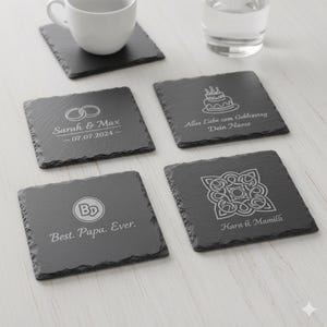 Op de afbeelding: Set van vijf vierkante leistenen onderzetters. Elke onderzetter heeft een uniek gegraveerd ontwerp, waaronder trouwringen, een taart, een monogram en een ingewikkeld patroon. Tekst bevat namen, data en zinnen zoals "Best. Papa. Ever."