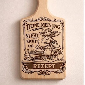 Puede incluir: Tabla de cortar de madera con asa, con un diseño grabado humorístico de una vaca cocinera removiendo una olla, con texto en alemán. El texto incluye "DEINE MEINUNG STEHT NICHT im REZEPT". Un pequeño letrero debajo dice "Lustiges Geschenk".