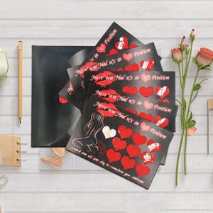 Könnte beinhalten: Eine Ansammlung schwarzer Karten mit roten Herzen und dem Text "Have you Had sex in 50 Position". Die Karten haben ein Rubbeldesign und eine Frauensilhouette. Ein schwarzer Umschlag ist ebenfalls vorhanden.