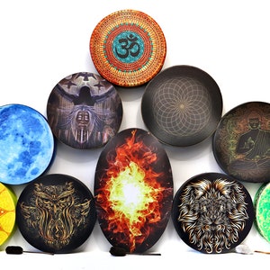 May include: Nine round hand drums with different designs, including a blue moon, a fire, a lion, an owl, a mandala, a Buddha, a green galaxy, a woman with a bird, and a geometric pattern. The drums are arranged in a pyramid shape.