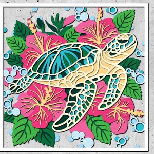 Op de afbeelding: Een kleurrijk papieren uitsnijwerk van een zeeschildpad die door een veld van roze hibiscusbloemen zwemt. De schildpad is groen, blauw en geel, en de bloemen zijn roze met gele centra.