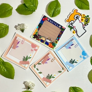 May include: Four blank note cards with floral and nature-themed designs. The cards are in various colors, including pink, blue, and brown. The cards have a blank space for writing notes or messages. The cards are perfect for journaling, scrapbooking, or adding a personal touch to gifts.