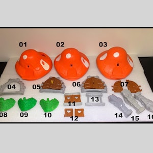 May include: A collection of orange mushroom-shaped components with white spots, along with various accessories. Includes gray archways, brown doors, green bushes, and gray and brown structural pieces. The items are numbered 01 through 16.