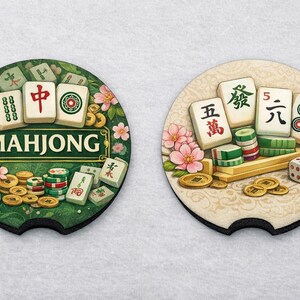 May include: Two round car coasters with a Mahjong theme. One coaster is green with the word "MAHJONG" and tiles. The other is beige with Mahjong tiles, dice, and coins. Both have a black edge and floral accents.