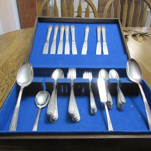 May include: A wooden box with a blue velvet lining containing a set of silverware. The silverware includes knives, forks, and spoons.