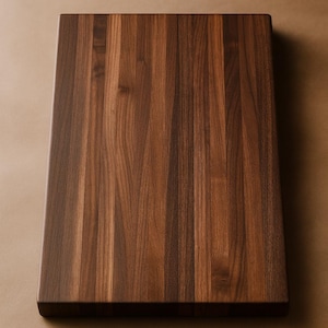 May include: A rectangular wooden cutting board with a rich, dark brown color. The wood grain is prominently displayed, running vertically across the surface. The board has a thick, sturdy appearance, suggesting durability and quality. It is a kitchen essential.
