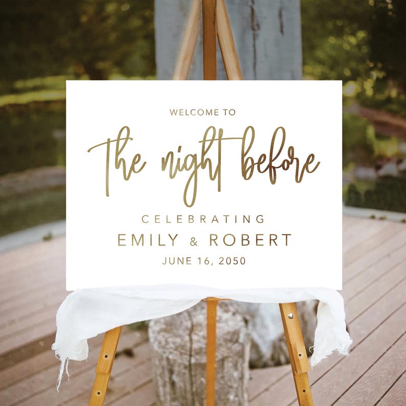 May include: White sign with gold lettering that reads "Welcome to the night before celebrating Emily & Robert June 16, 2050".