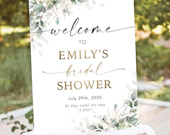 Puede incluir: Un letrero blanco sobre un caballete con las palabras "welcome to Emily's bridal shower" en letras negras y doradas. El letrero incluye la fecha 29 de julio de 2050 y el texto "45 días hasta que diga 'I DO!'". Acentos florales enmarcan el texto.