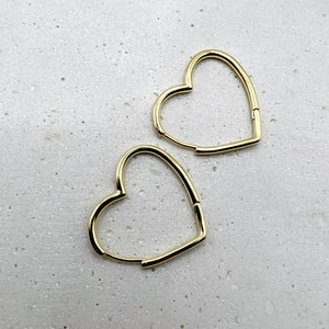 Peut inclure: Une paire de boucles d'oreilles cr&eacute;oles en forme de c&oelig;ur dor&eacute;es. Les boucles d'oreilles sont simples et &eacute;l&eacute;gantes, et seraient un excellent cadeau pour toute occasion.