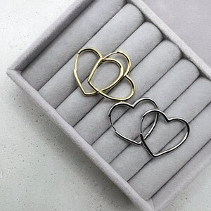 Peut inclure: Deux paires de boucles d'oreilles cr&eacute;oles en forme de c&oelig;ur, une paire en or et une paire en argent, pr&eacute;sent&eacute;es dans un &eacute;crin &agrave; anneaux en velours gris.