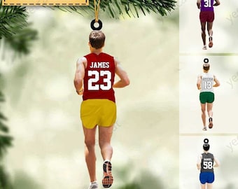 Könnte beinhalten: Ein personalisierter Weihnachtsbaumschmuck mit einem Läufer in einem roten und gelben Laufoutfit. Der Schmuck ist mit einem Namen und einer Nummer anpassbar. Der Text "NAME, NUMBER&COLOR CAN BE CHANGED" wird oben auf dem Schmuck angezeigt.