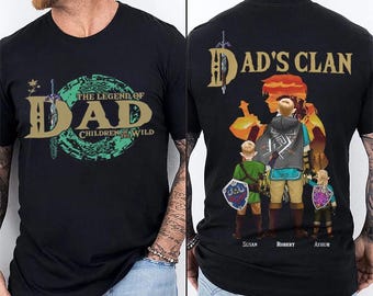 May include: Black t-shirt featuring the text "THE LEGEND OF DAD CHILDREN OF THE WILD" on the front. The back of the shirt displays a graphic of a family with the words "DAD'S CLAN" and the names "Susan, Robert, Arthur".