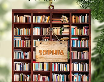 May include: A wooden ornament shaped like a bookshelf filled with books. A wooden sign hangs from the top of the bookshelf with the name "Sophia" written on it.