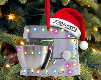 May include: A silver stand mixer with a red Santa hat on top. The mixer is decorated with colorful Christmas lights. The hat has the text "YOUR NAME" on it.