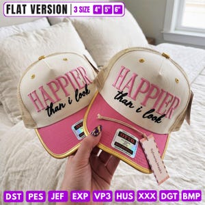 May include: Two cream and pink trucker hats with mesh backs and gold trim on the brims. The front panels feature the embroidered pink text HAPPIER and black cursive text than i look. A tag reads Sylvania Masks and Otto Classic.