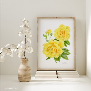 May include: A watercolor painting of yellow roses with green leaves. The painting is framed and displayed on a shelf with books.