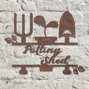 May include: A weathered metal sign for a potting shed, with a trowel, a plant, and a garden fork design. The words "Potting Shed" are written in a decorative font. The sign is mounted on a white brick wall.
