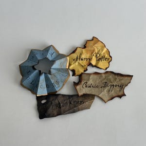 Ornamento com os nomes dos torneios de bruxos