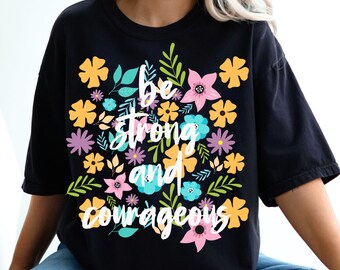 May include: Black t-shirt with a floral design and the text "Be strong and courageous" in white.