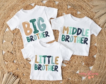 May include: Three white t-shirts with colorful text. The shirts say "Big Brother", "Middle Brother", and "Little Brother".