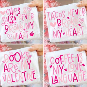 Puede incluir: Cuatro camisetas blancas con texto rosa. Las camisetas tienen frases como "Chips & Salsa Never Broke My Heart", "Tacos Never Broke My Heart", "Books Are My Valentine" y "Coffee Is My Love Language".