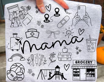 May include: A light gray t-shirt featuring the word mama in black script, surrounded by black line art icons including a laptop, map pins, a bandage, a smartphone, a nurse cap, a bow, a sun, a suitcase, a plane, a drink, a rainbow, kitchen tools, flowers, books, an apple, sports balls, a playground, and a grocery store.