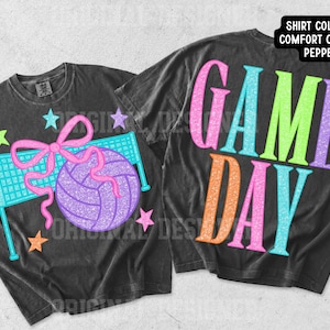 May include: Two pepper-colored t-shirts featuring a glittery graphic design. One shirt displays a volleyball, a net, and a pink bow with stars. The other shirt features the text "GAME DAY" in large, colorful, glittery letters. A label notes the shirt color is Pepper.