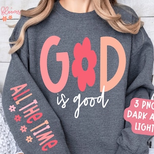 May include: A gray sweatshirt with the words "GOD is good" and "ALL THE TIME" printed on it. The words are in pink and white. There is a pink flower graphic between the words "GOD" and "is good".