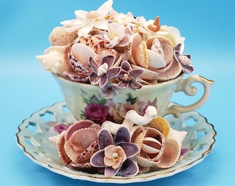 Vintage teacup with seashell flower bouquet centerpiece.