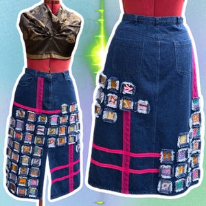 May include: A denim skirt with a patchwork design featuring squares of fabric in various colors and patterns. The skirt has pink ribbon trim and a front slit.
