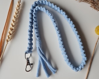 May include: A light blue crocheted key chain with a silver clip and a tassel.