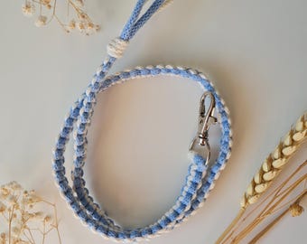 May include: A blue and white braided lanyard with a silver clip. The lanyard is made of cotton cord and is approximately 18 inches long.