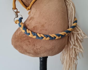 May include: A brown plush rocking horse with a blue and yellow braided rope reins. The horse has a long, white mane and tail.