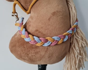 May include: A brown plush horse head with a braided rope halter in blue, pink, and yellow.