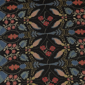 May include: Close-up of a patterned fabric with a repeating design. The pattern features black, blue, red, and tan floral and leaf motifs. The fabric has a textured appearance, with a dark background and detailed, symmetrical elements.