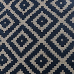May include: Close-up of a fabric with a geometric diamond pattern. The design features dark navy blue diamonds set against a light beige background. The repeating pattern creates a textured, woven appearance, suitable for upholstery or home decor.