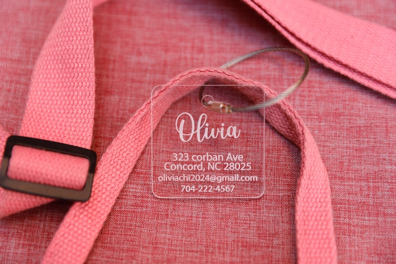 May include: A clear plastic luggage tag with the name Olivia, address 323 corban Ave, Concord, NC 28025, email oliviacchi2024@gmail.com, and phone number 704-222-4567.