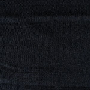 May include: A close-up of a dark blue fabric with a subtle texture. The fabric has a smooth, even surface with a slight sheen.