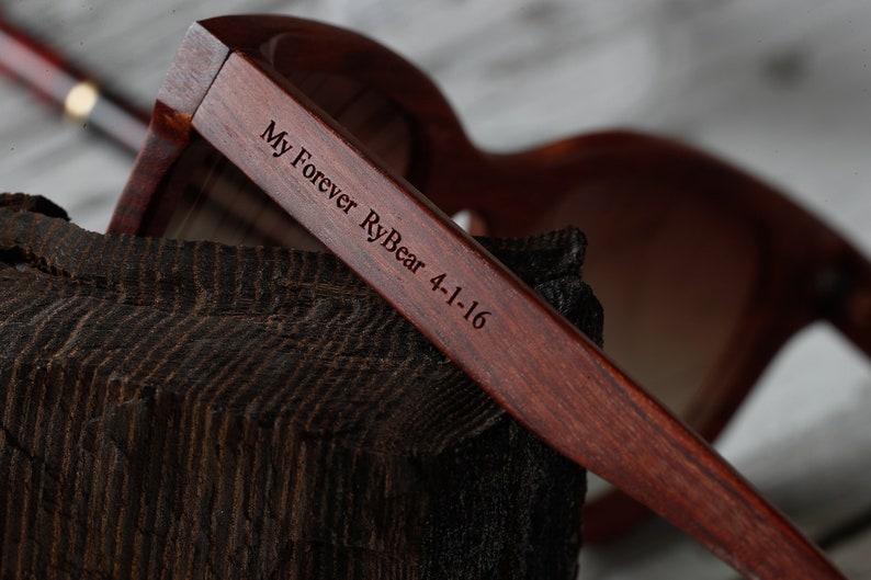 May include: Close-up of a wooden pair of sunglasses with the text "My Forever RyBear 4-1-16" engraved on the side.
