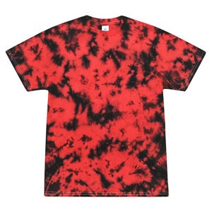 Puede incluir: Una camiseta roja y negra teñida con tinte anudado. La camiseta tiene cuello redondo y mangas cortas. El patrón de teñido anudado presenta una base roja vibrante con manchas negras irregulares en toda la tela. La camiseta está hecha de un material suave.